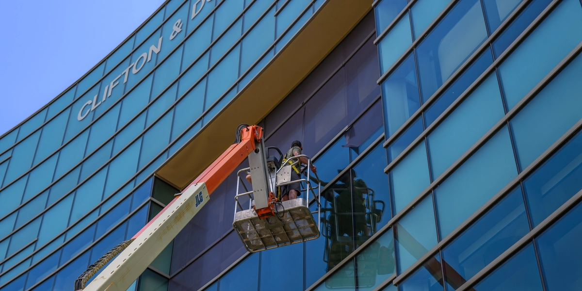 Person on crane adding a new banner to Wharton Center