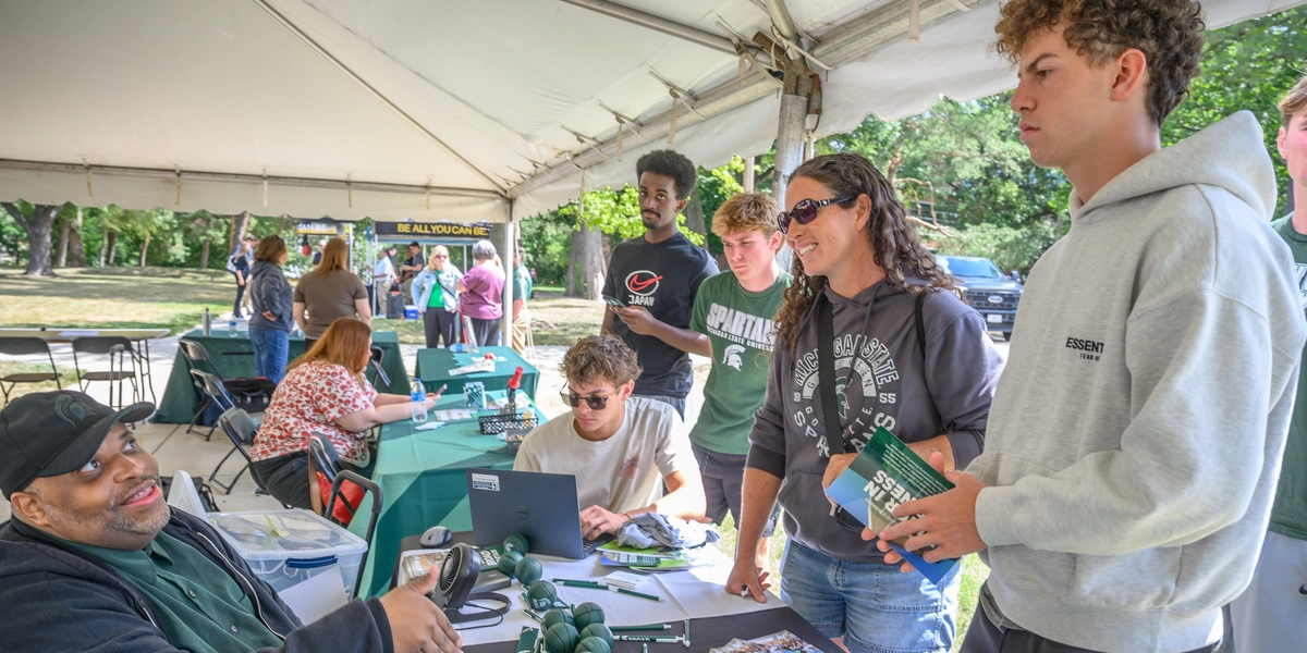 A prospective family speaking to a volunteer at Green and White Day