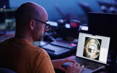 Artist Jan Tichy working on a laptop in planetarium.