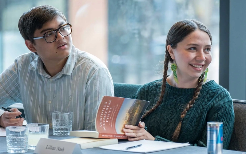 Students smile and listen during a forum.