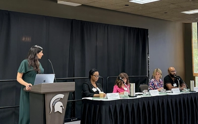 Individuals from different organizations in Michigan speak on a panel at a conference of researchers and industry professionals.