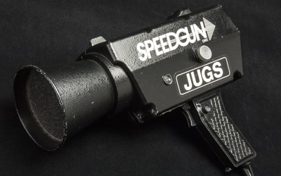 Black and white photo of a prototype pitch speed radar gun. Printed on the items in white capital letters SPEEDGUN ONE JUGS.
