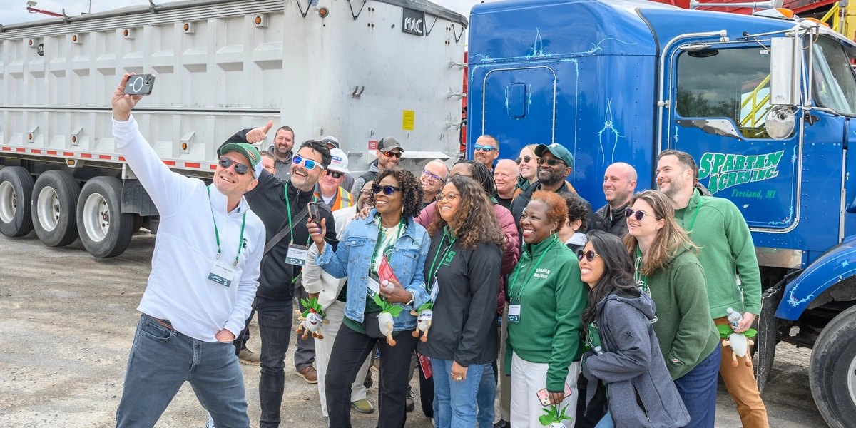 Spartans take a selfie in front of a semi truck