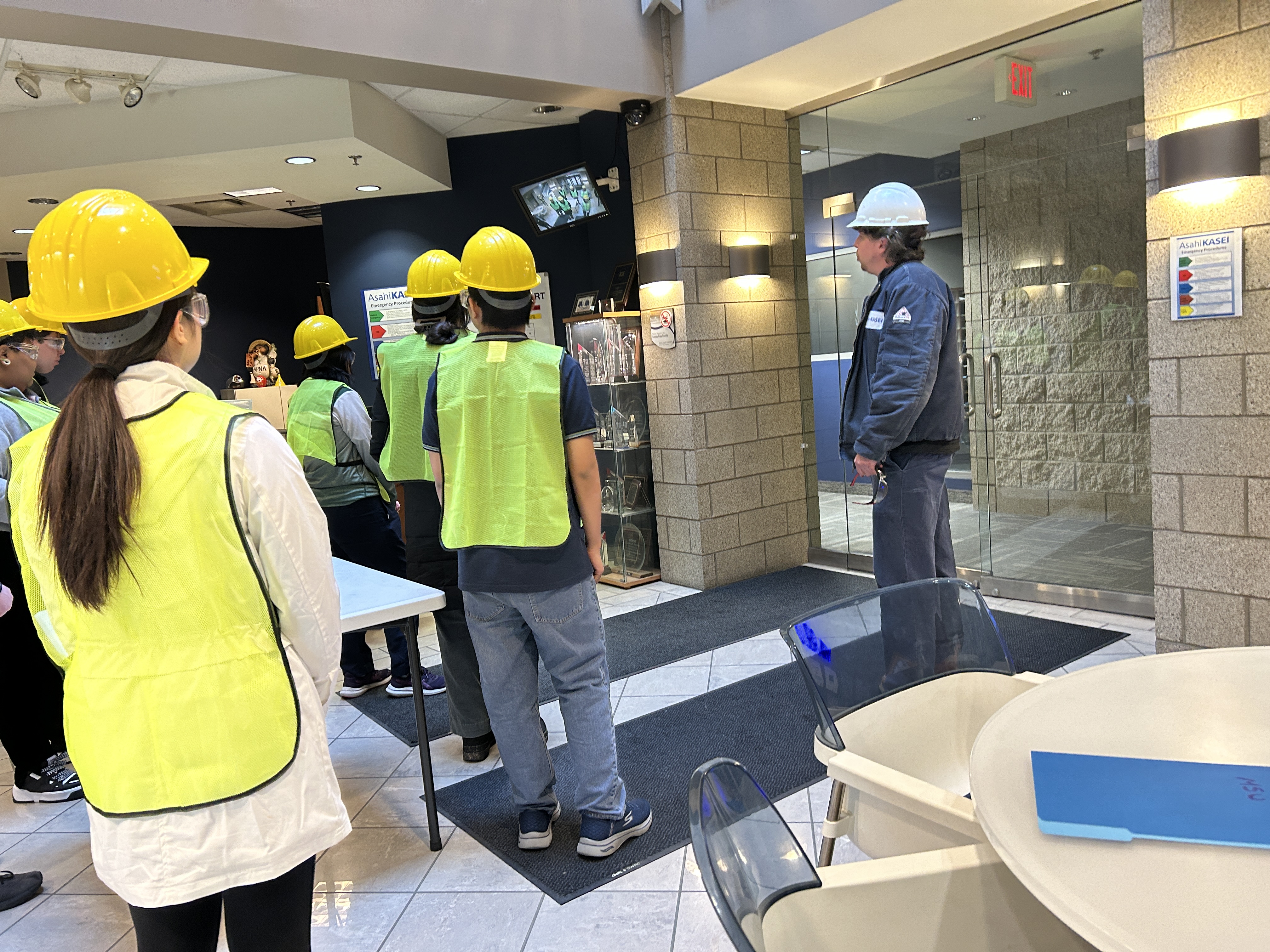 students wearing hard hats visiting a building