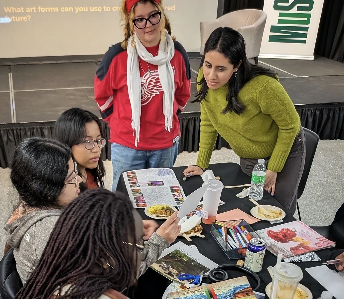 Students gather around a table and work on an activity together