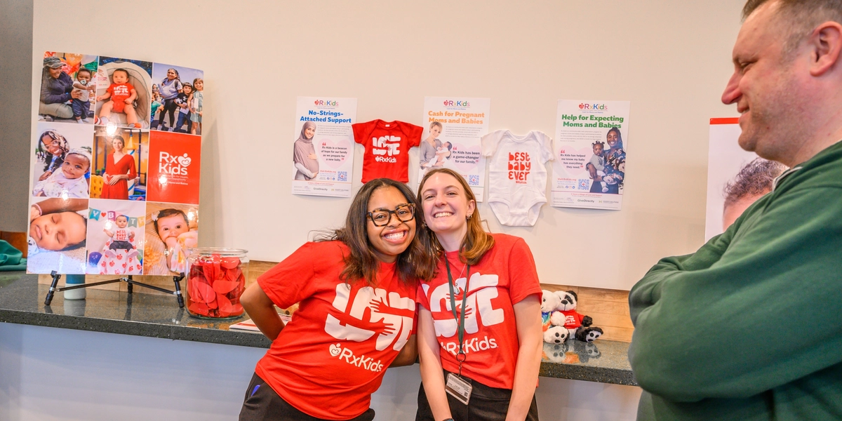 Two people smile in red Rx Kids shirts