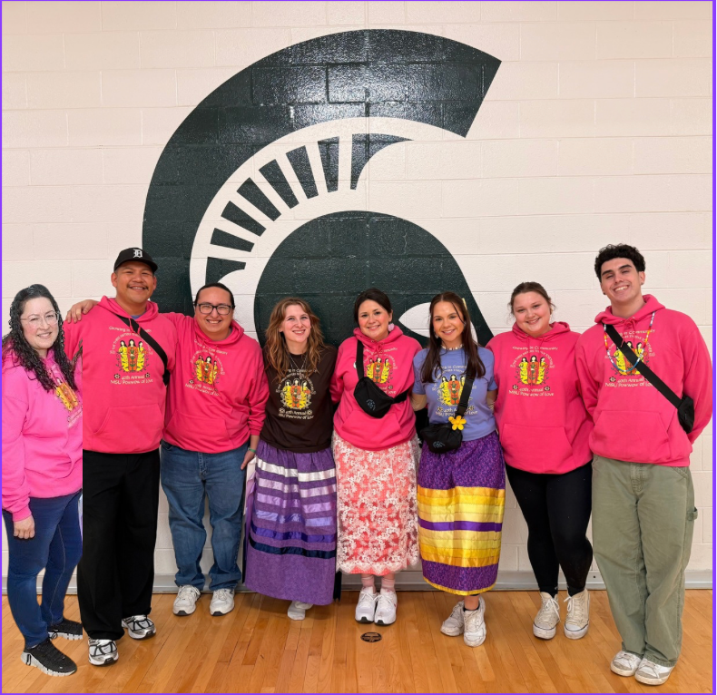 A group of students and staff wearing themed hoodies