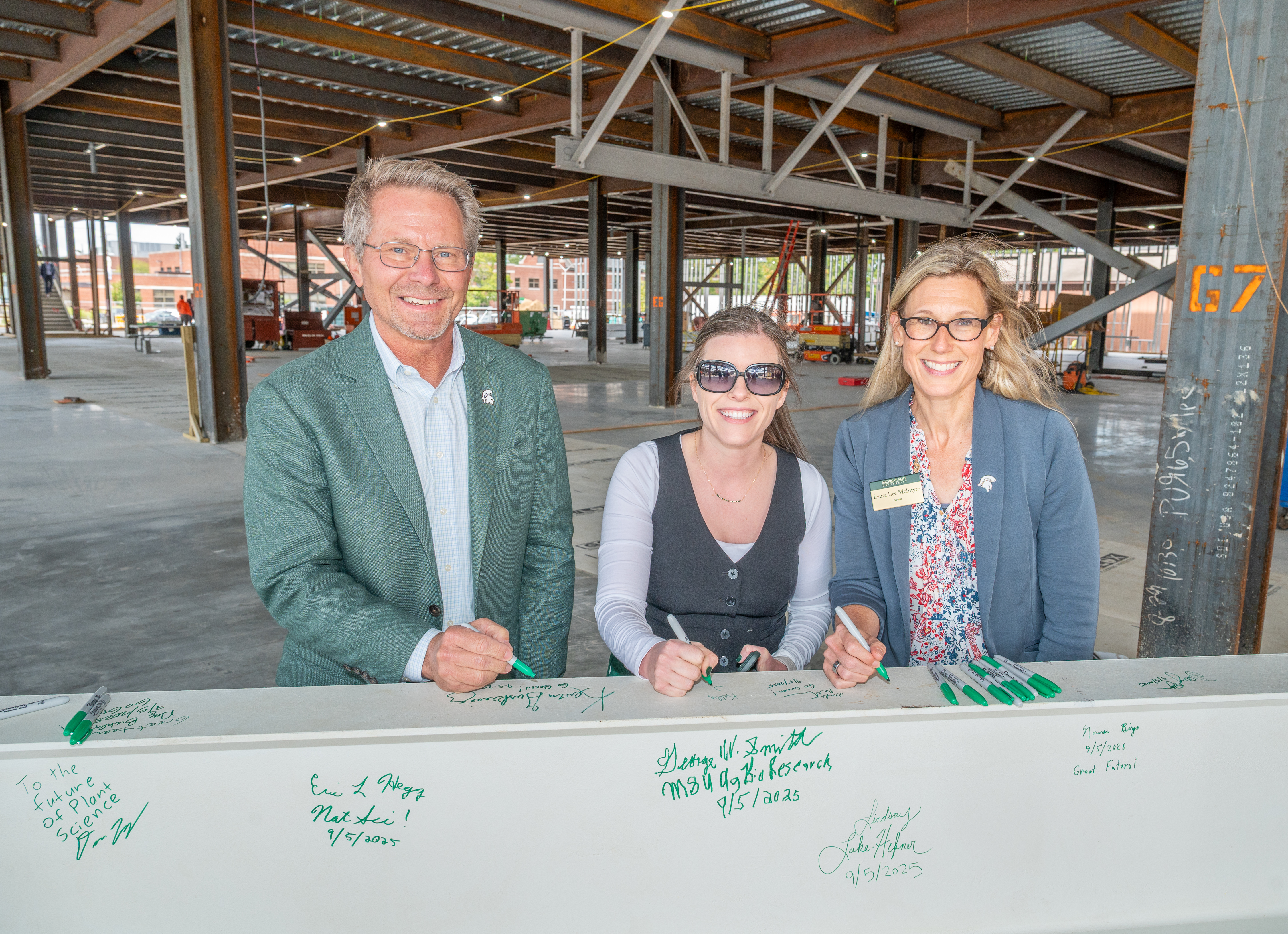 Laura Lee McIntyre signing a beam at the Plant and Environmental Sciences building