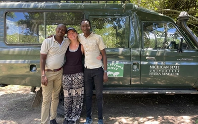 Benson, Woerner and Ben in front of a vehicle at the research camp