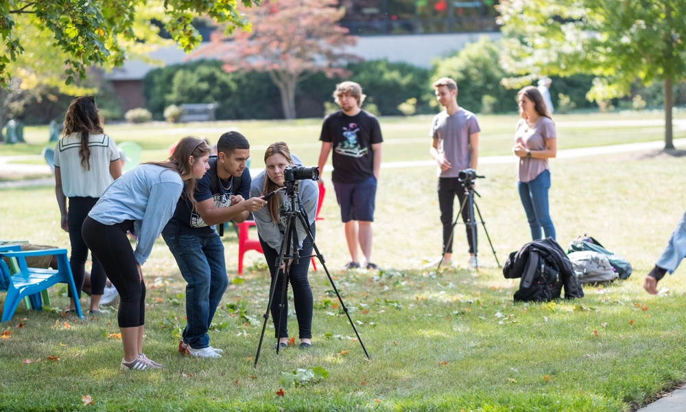 Students using a camera outdoors.