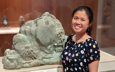 Yulian Wu standing with a statue