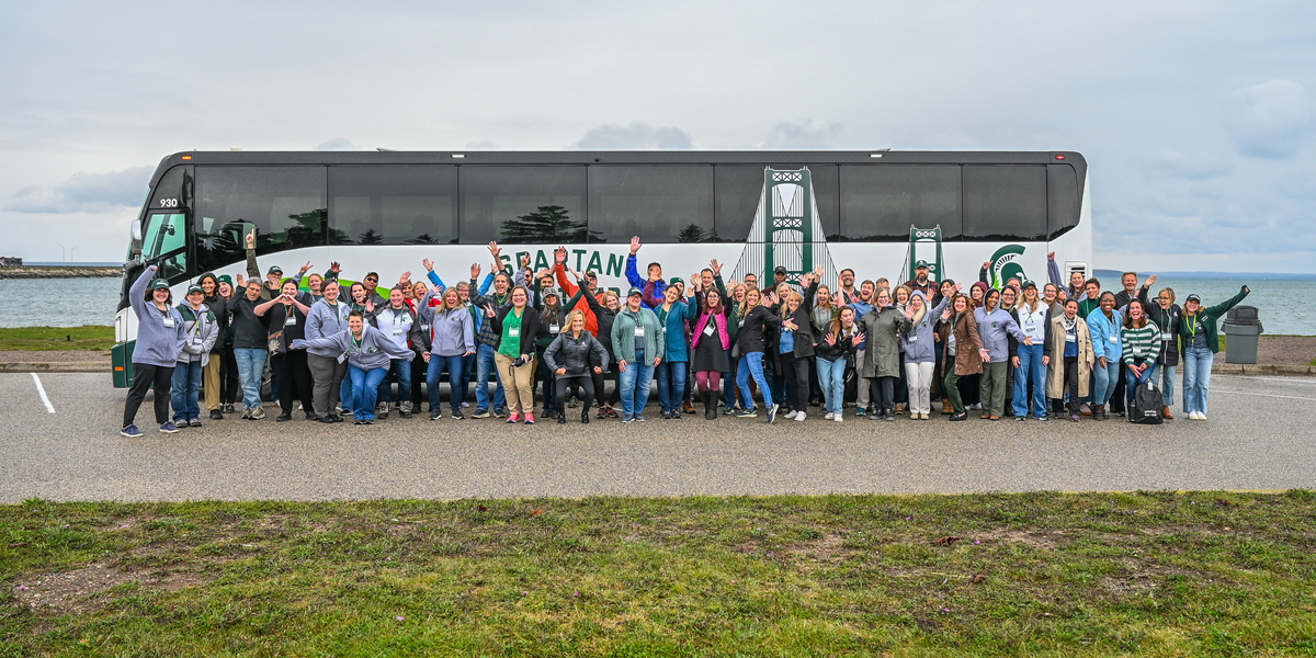 Participants of the Spartan Bus Tour 2025 Regional Route Upper Peninsula pose in front of the bus.