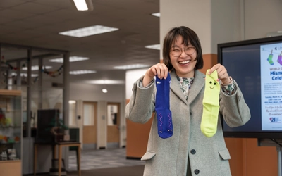 A student holds up a mismatched sock craft