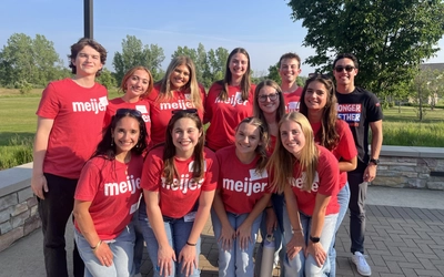 People in red Meijer shirts gathered for a group photo.