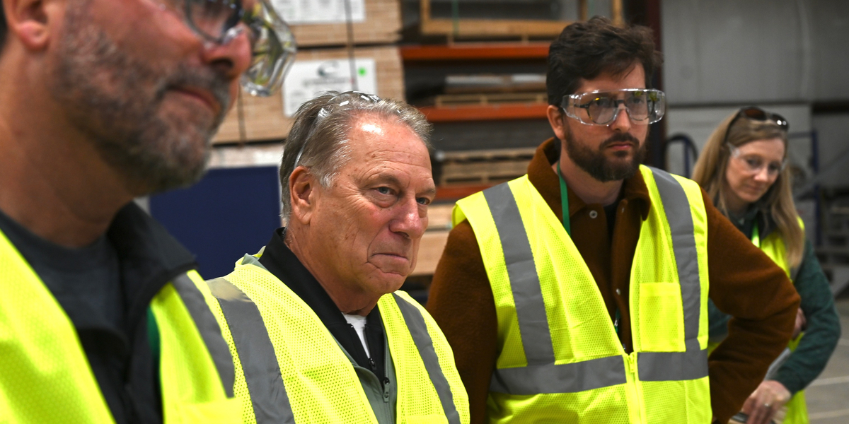 Several people wearing bright yellow safety vests - including MSU men