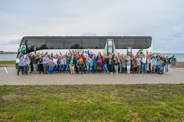 Participants of the Spartan Bus Tour 2025 Regional Route Upper Peninsula pose in front of the bus.