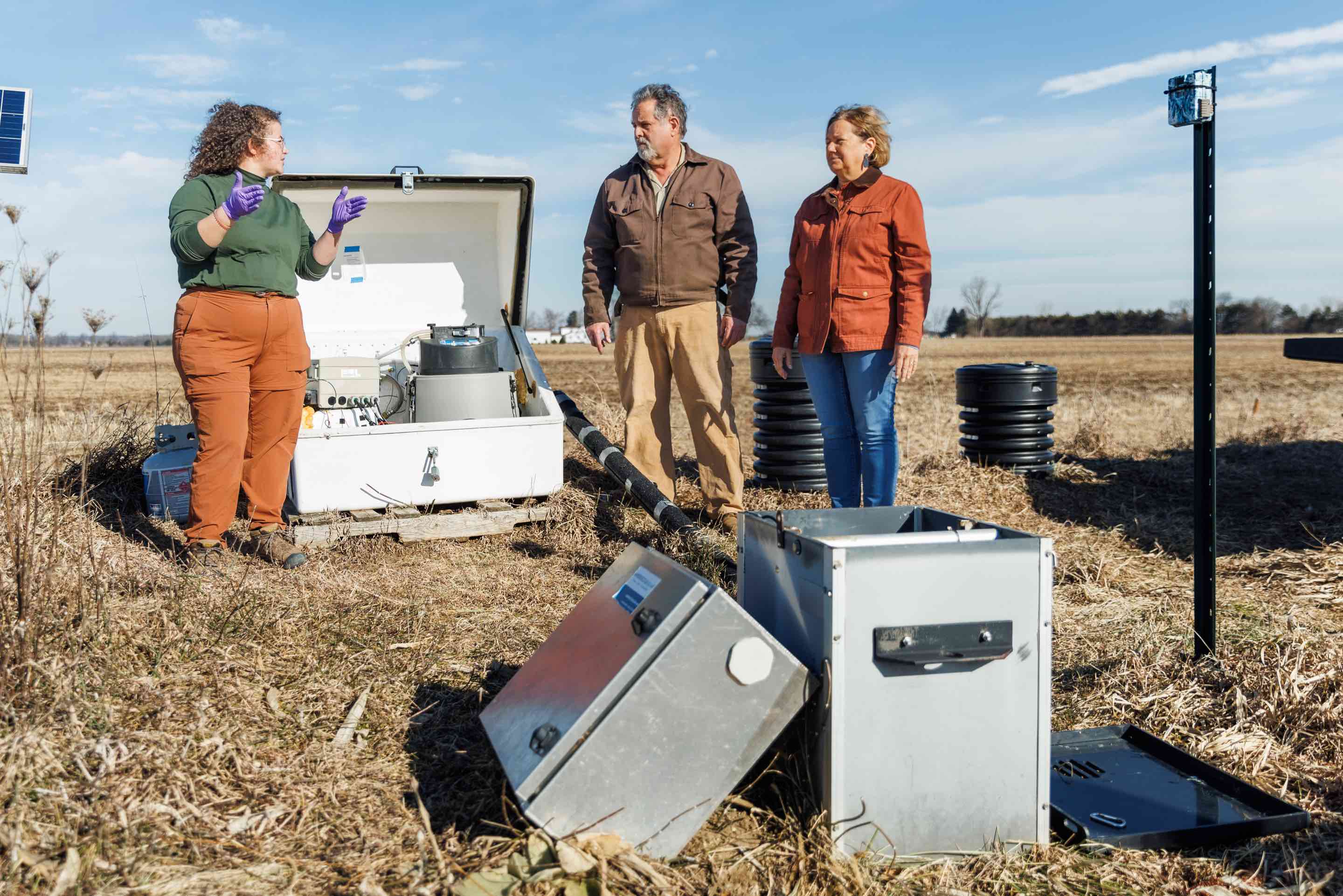 Jim and Laurie Isley, dedicated stewards of Sunrise Farms in Palmyra, Michigan, standing proudly in front of their farm's equipment and infrastructure, showcasing the real-world application of sustainable agricultural practices.