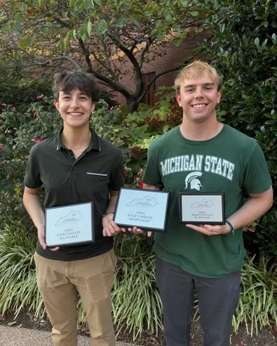 Joanna Gusis and Stephen Lewis pose holding three plaques