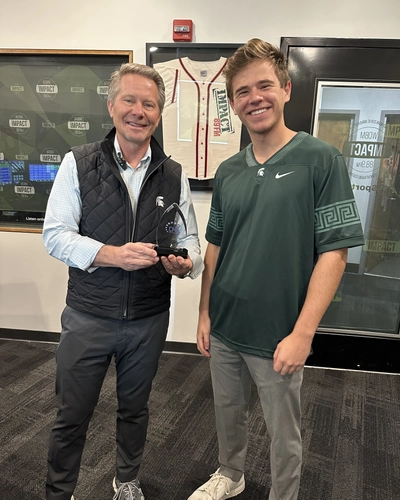 MSU president Kevin Guskiewicz and sports director Joe DesVergnes-Christy poses with the CMA Pinnacle Award for Audio Outlet of The Year.