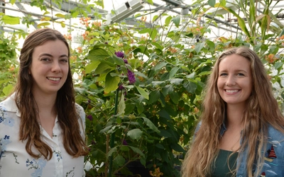 Abigail Bryson and Emily Lanier in front of a plant