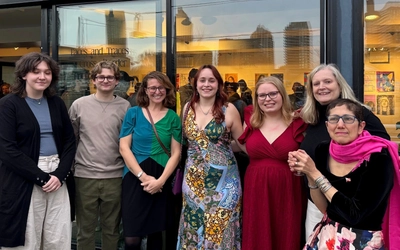 d’Ann de Simone and Rebecca Malouin with MSU students at the Faces and Traces: A Cross-Border Portrait Project exhibition at Stackt Market in Toronto.