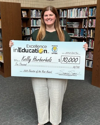 Kelly Herberholz with the $10,000 prize from the Michigan Lottery's Excellence in Education Program.