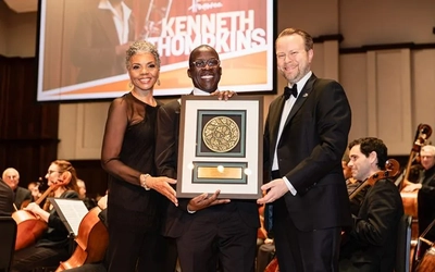 Kenneth Thompkins is honored with a plaque by Faye Alexander Nelson and President and CEO Erik Rönmark