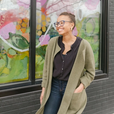 Avery Williamson standing in front of window art