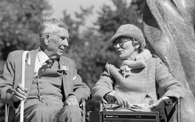 Black and white photo of George Alderton speaking with Irene Jungwirth