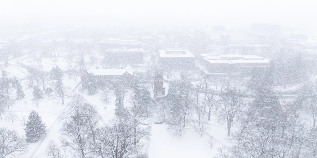 Aerial view of north campus facing south towards Beaumont Tower during heavy snowfall.